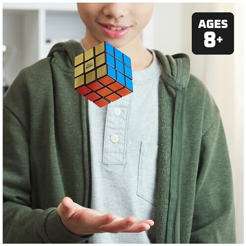Boy holding a Rubik's Cube with ages 8+ label.